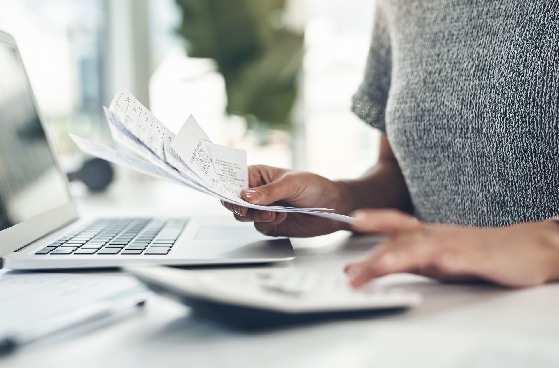 Gros plan d’une femme d’affaires méconnaissable calculant les finances dans un bureau